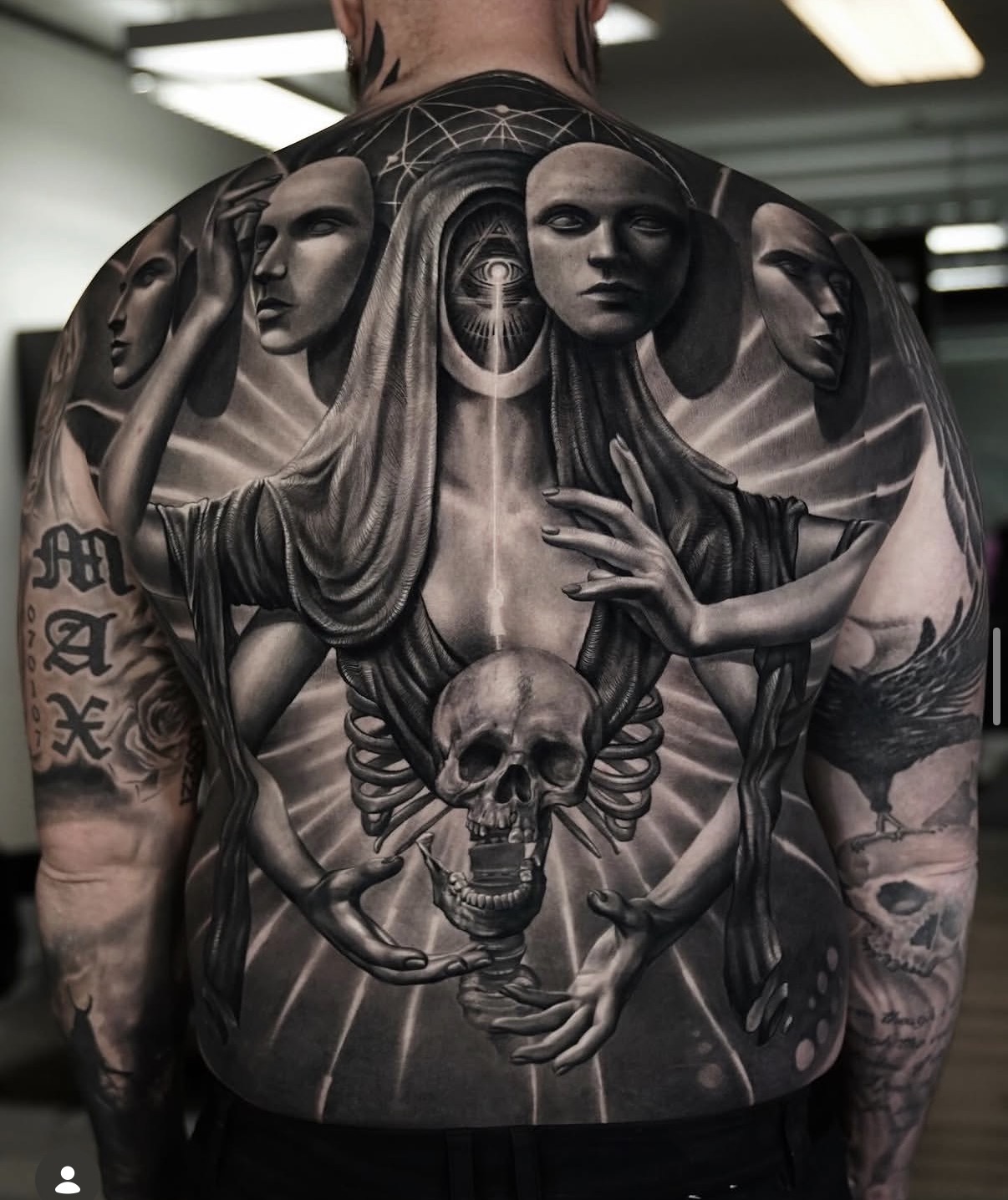 Full-chest black-and-grey realism tattoo with faces and skulls